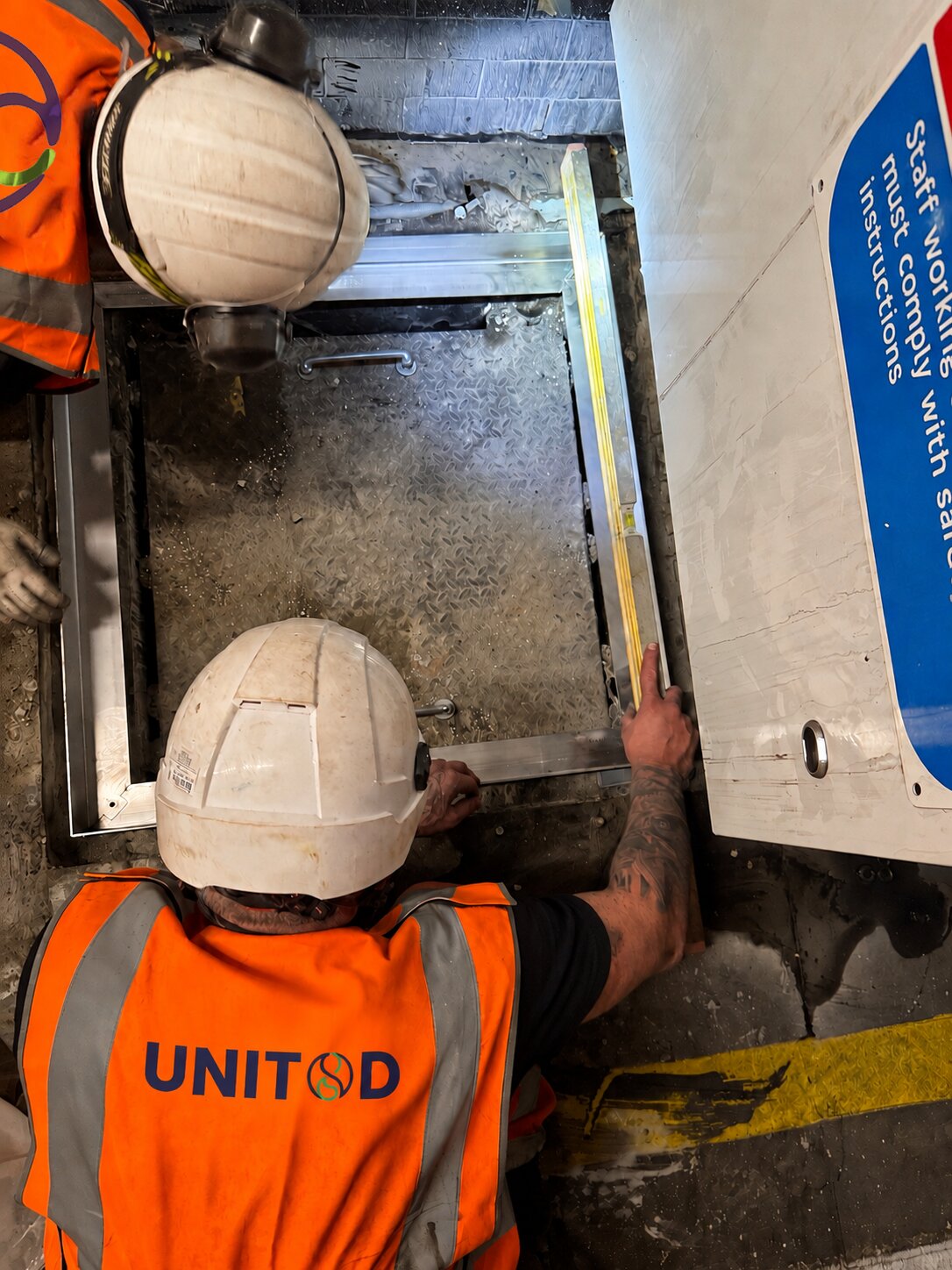 Operatives installing an access frame in a platform floor