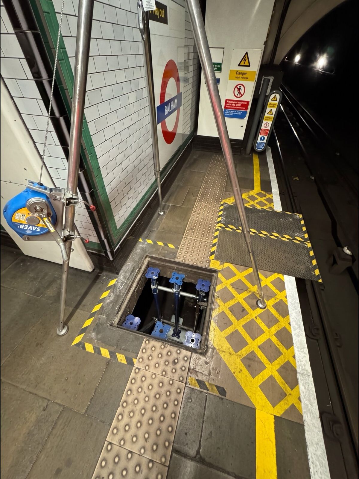 Open access hatch behind barriers on a London Underground platform
